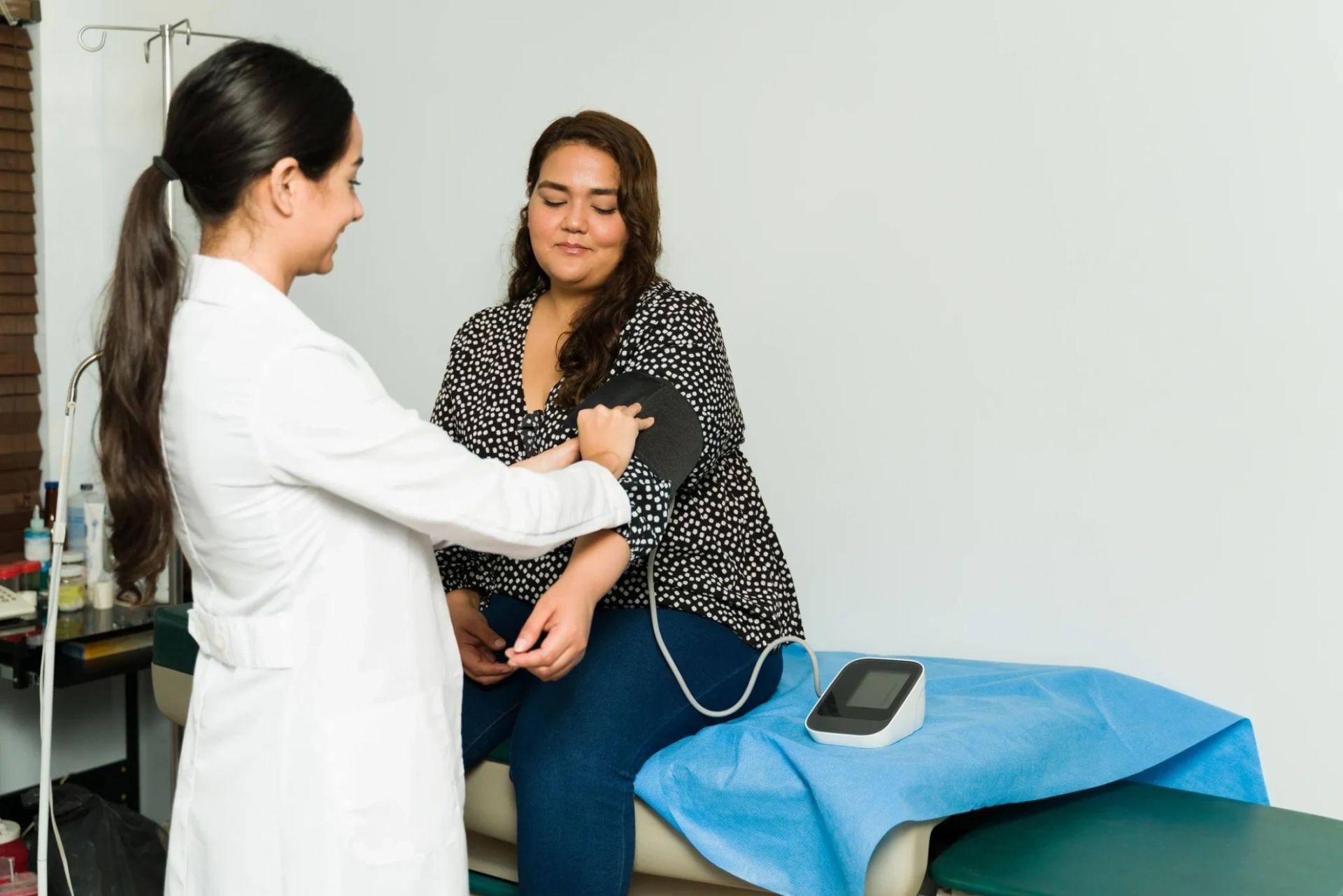 Clinician taking an adult patient's blood pressure at Crenshaw Industrial Medical Clinic
